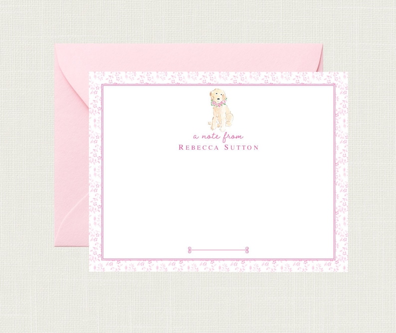 May include: A white card with a pink floral border. A watercolor illustration of a golden retriever wearing a pink flower collar is in the top center of the card. The text "a note from Rebecca Sutton" is below the illustration.