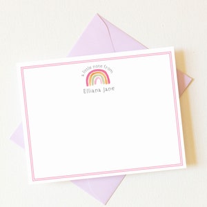 May include: A white stationery card with a pink border. The card features a rainbow with the text "a little note from" and the name "Elliana Jane".