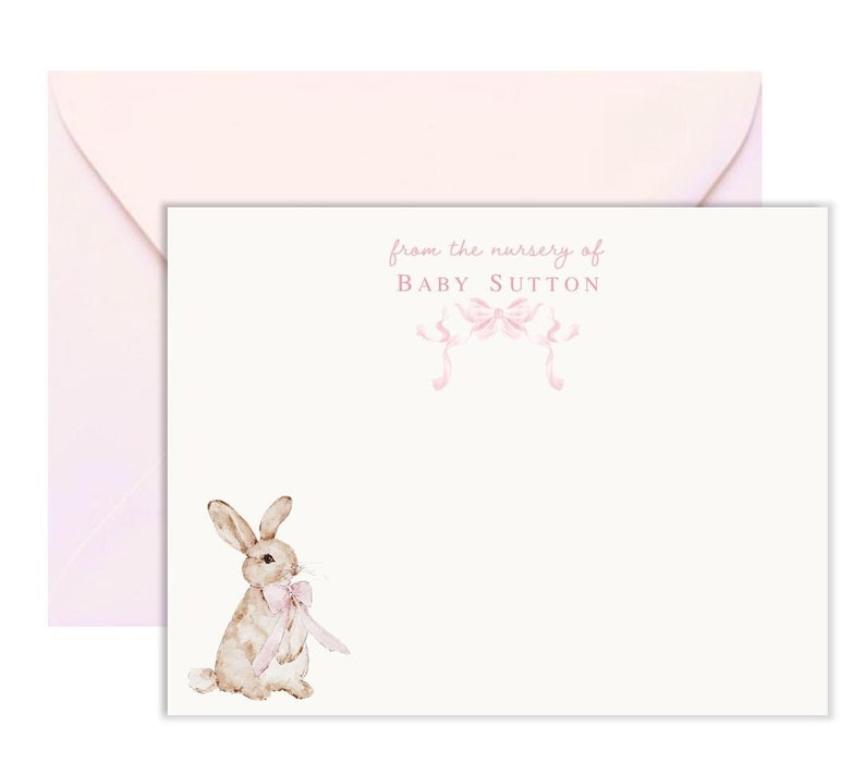 Puede incluir: Una tarjeta blanca con texto rosa que dice "from the nursery of BABY SUTTON". Hay dos lazos rosas sobre el texto. Una ilustraci&oacute;n de acuarela de un conejo marr&oacute;n con un lazo rosa est&aacute; en la esquina inferior izquierda de la tarjeta.