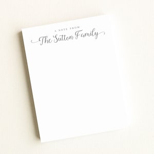 May include: A white notepad with the text "A Note From The Sutton Family" printed in black at the top.