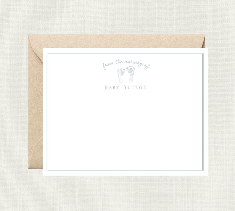 May include: A white card with a blue border and a blue footprint design. The text "from the nursery of Baby Sutton" is printed on the card.