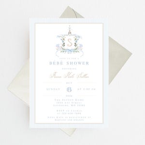 Pode incluir: Um convite para um ch&aacute; de beb&ecirc; em listras azuis e brancas com uma ilustra&ccedil;&atilde;o em aquarela de um monograma com tema parisiense. O convite diz "Join us for a Bebe Shower honoring Anna Kale Sutton, Sunday, October 6th at 3:00 PM. The Sutton Home, 1204 Any Street, Anywhere, MO 12345. RSVP to Lauren at 123-456-7890. Anna Kate is registered at Babylist and Amazon."