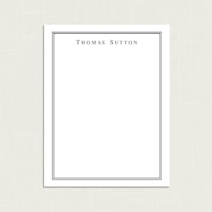 May include: A white stationery card with a black double border and the text "THOMAS SUTTON" printed in black at the top.