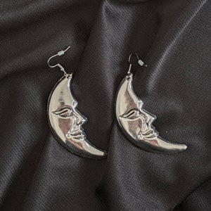 a pair of earrings with a moon on it