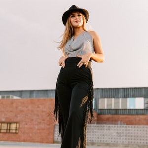 a woman wearing a hat and black pants