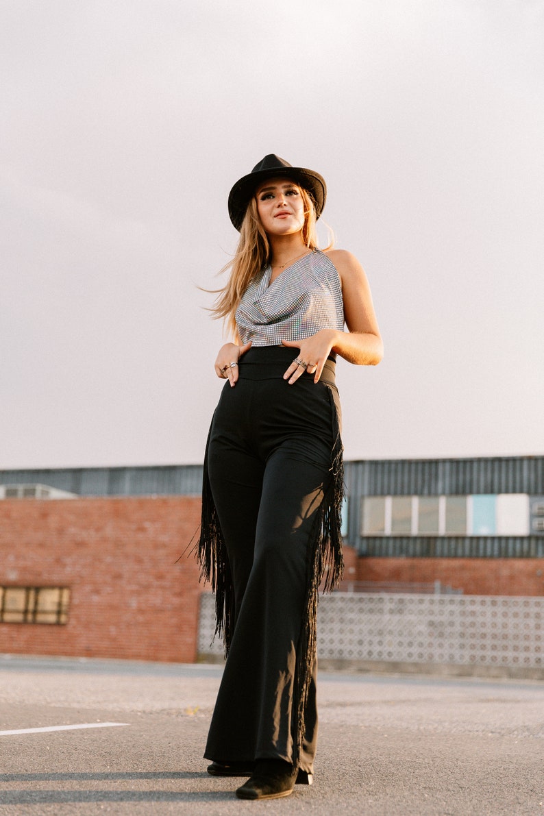 a woman wearing a hat and black pants