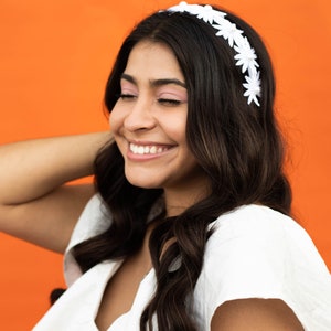a woman with long hair wearing a white headband