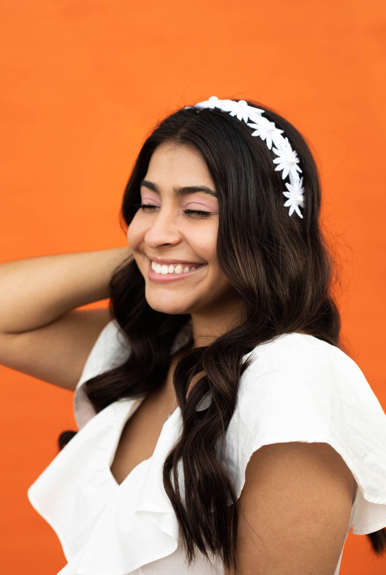 a woman with long hair wearing a white headband