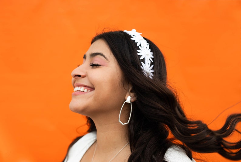 a woman with long hair wearing a white headband