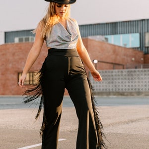 a woman wearing cowboy fringe pants