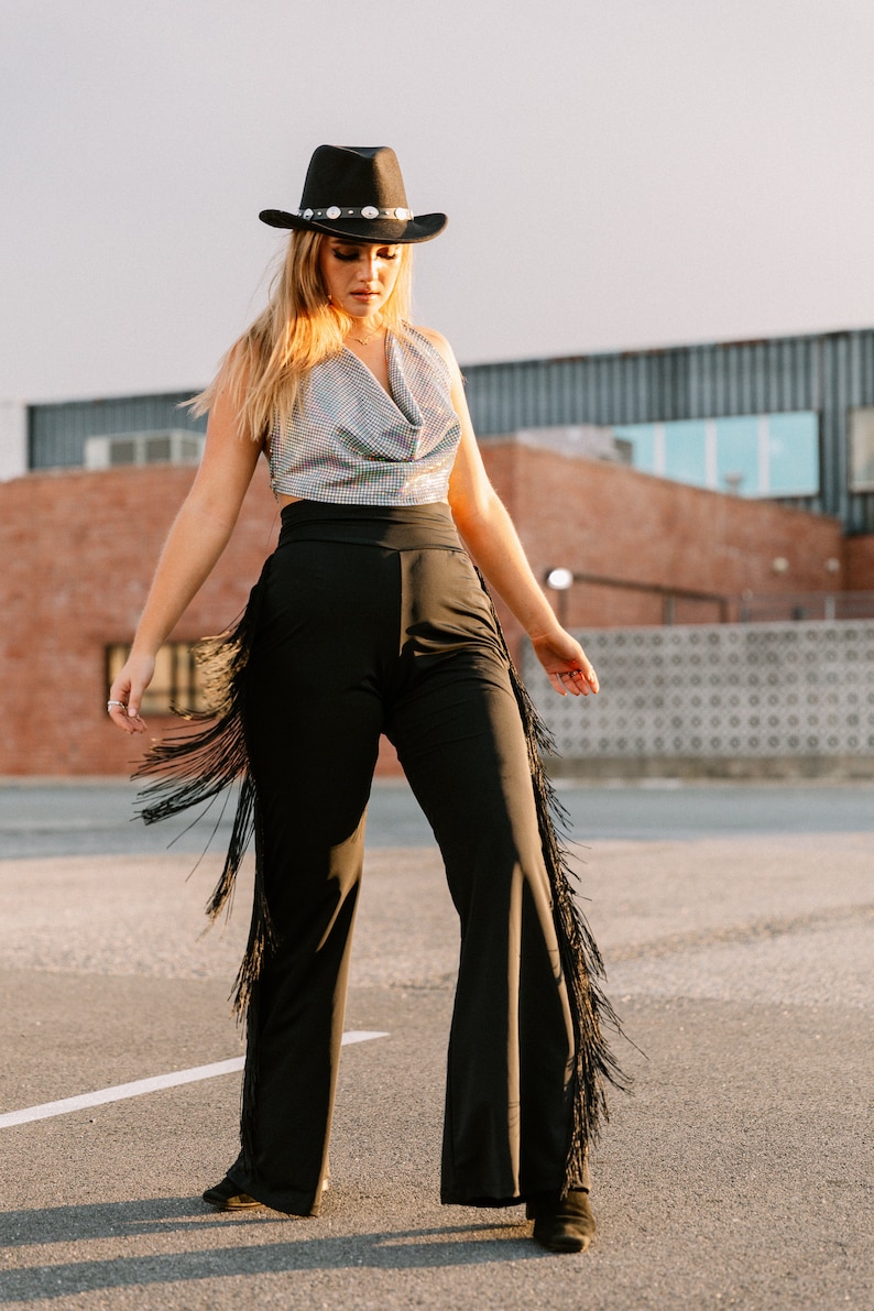 a woman wearing cowboy fringe pants