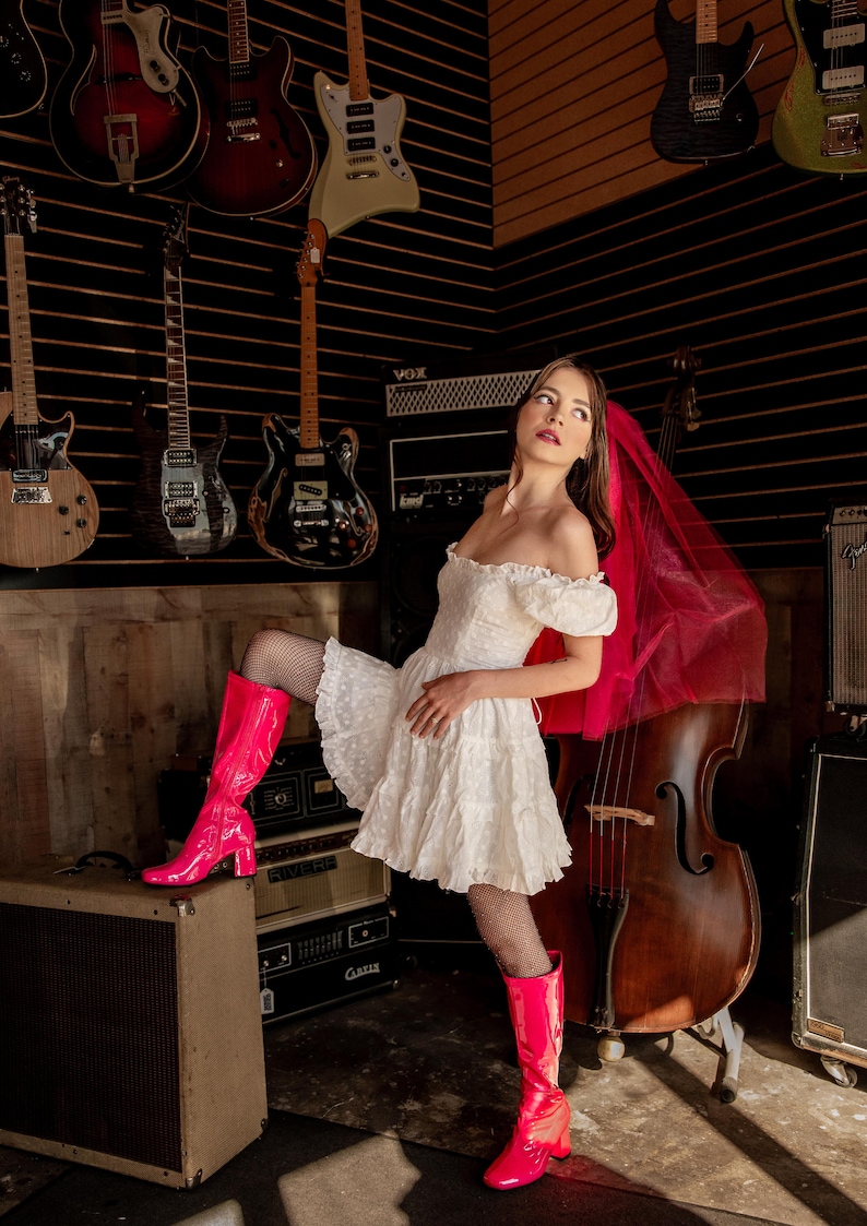 a bride wearing a pink veil and boots