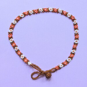 The beaded choker necklace is fastened in a loop with its toggle closure visible at the bottom.