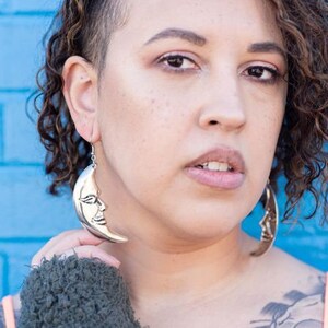 a close up of a person wearing large hoop earrings