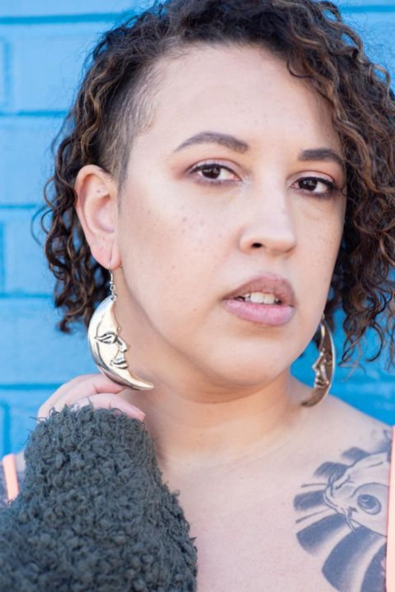 a close up of a person wearing large hoop earrings