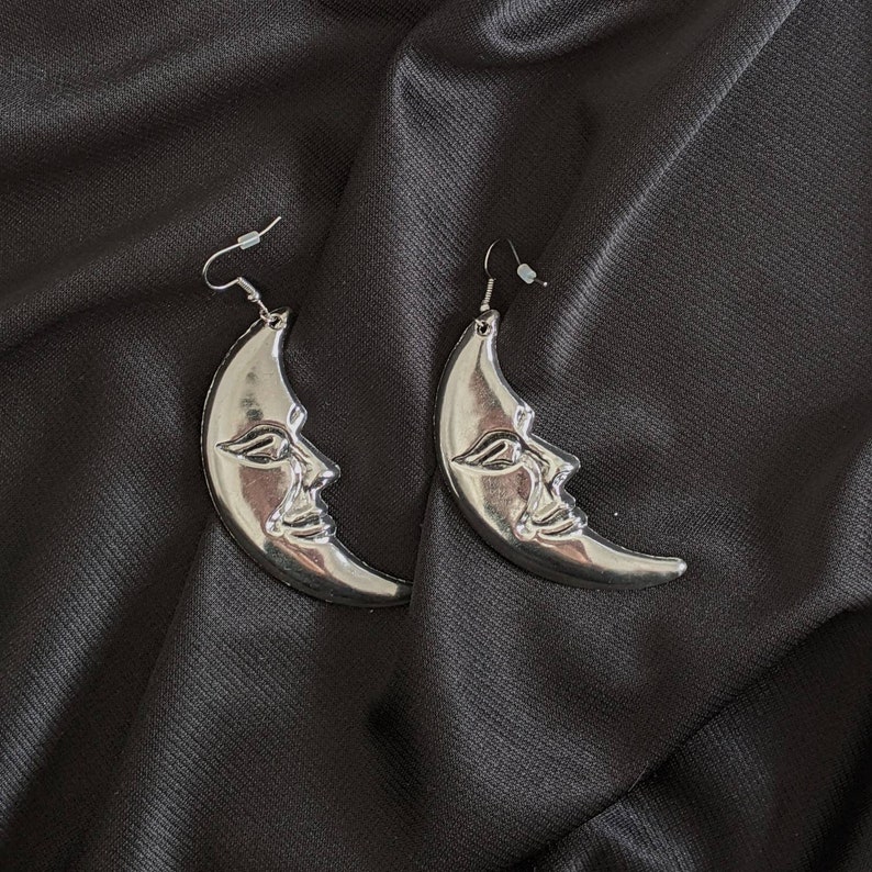a pair of earrings with a moon on it