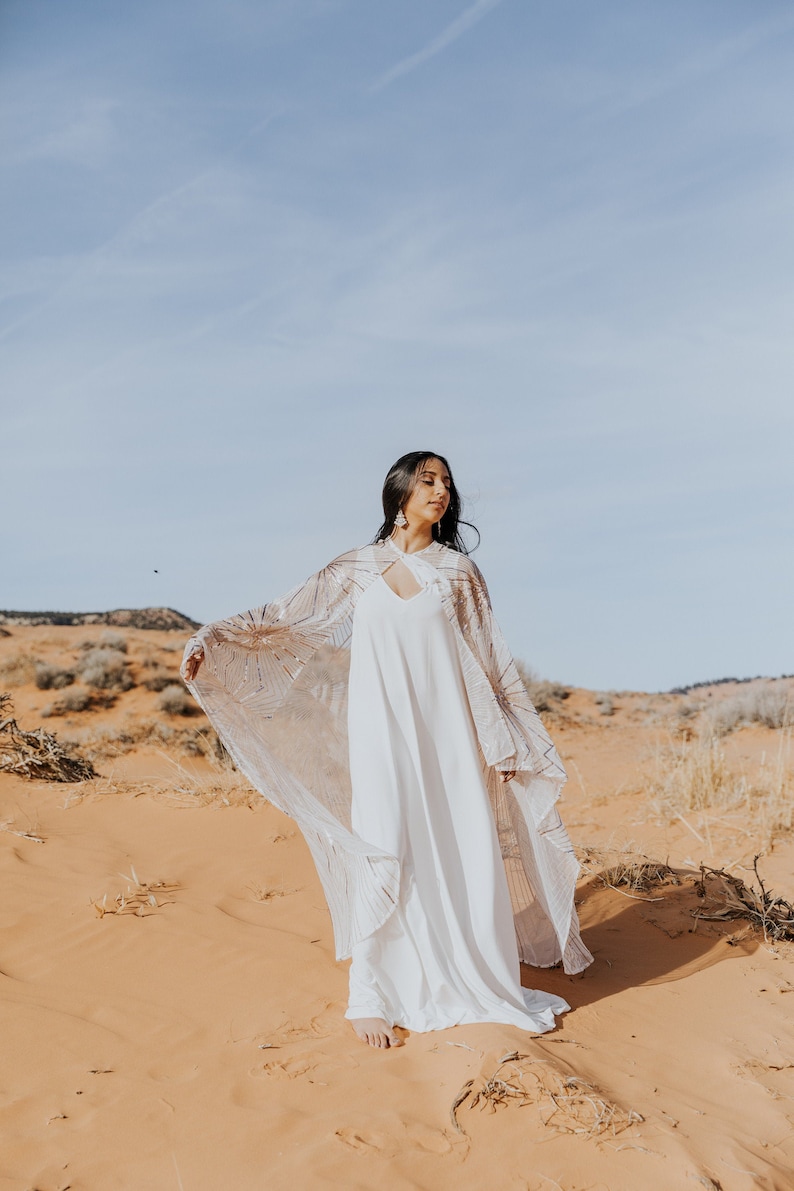 a bride in a white dress in the desert