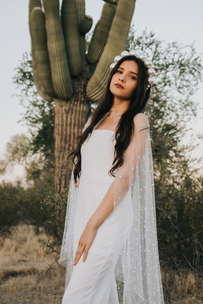 a bride standing in front of a large cactus
