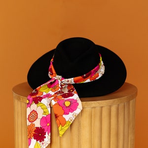 a hat and a scarf are on top of a wooden box