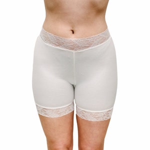 May include: White cotton shorts with a lace trim around the waist and legs.