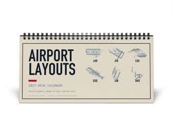 May include: A 2027 desk calendar with a spiral binding at the top. The cover is beige with dark blue text reading AIRPORT LAYOUTS and 2027 DESK CALENDAR. It features blue technical diagrams of six airports labeled LHR, JFK, CDG, DXB, SIN, and AMS.