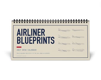 Könnte beinhalten: Ein Tischkalender für 2027 mit Spiralbindung an der Oberseite. Das Deckblatt ist beige mit dunkelblauem Text, der AIRLINER BLUEPRINTS und 2027 DESK CALENDAR lautet. Es zeigt acht Strichzeichnungen von Flugzeugen und ein kleines rotes Rechteck.