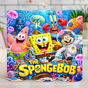 Pode incluir: Um copo cilíndrico com uma cena subaquática vibrante apresentando Bob Esponja Calça Quadrada, Patrick Estrela, Lula Molusco, Sr. Siriguejo e Sandy Bochechas. O design inclui o texto THE SPONGEBOB, águas-vivas, uma casa abacaxi e uma cabeça de pedra.