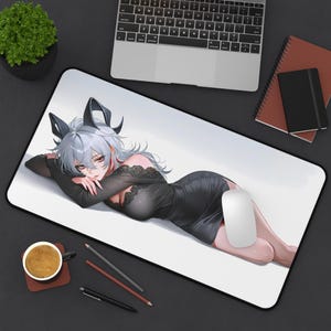 May include: A rectangular desk mat featuring an anime-style illustration of a character with silver hair and dark horns, wearing a black lace-trimmed dress. The character is lying down in a reclining pose against a plain white background.