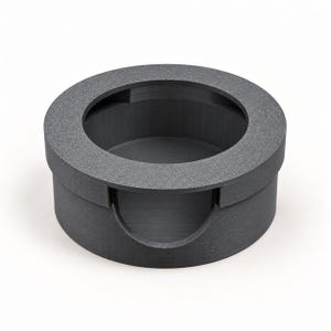 以下が含まれることがあります： マットな質感のダークグレーの円形ホルダー。上部は広く開いており、側面には半円形の切り込みがあります。内部は空洞になっており、小さなアイテムを収納したり整理したりするための構造をしています。