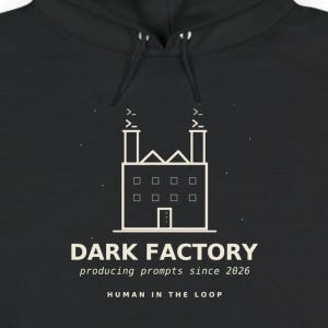 May include: A black hoodie featuring a white line-art graphic of a factory with two chimneys emitting code symbols. Below the factory, the text reads DARK FACTORY, producing prompts since 2026, and HUMAN IN THE LOOP in a clean, sans-serif font.