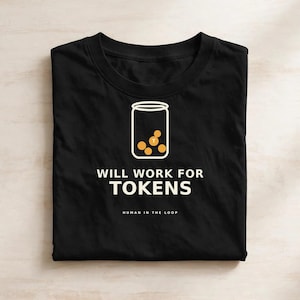 May include: A black crew neck t-shirt featuring a white graphic of a jar filled with orange tokens. Below the jar, the text reads WILL WORK FOR TOKENS in white capital letters, followed by the smaller text HUMAN IN THE LOOP in white.