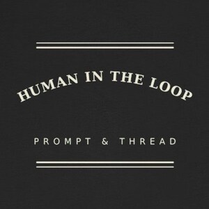 以下が含まれることがあります： 黒い布地に白い文字でHUMAN IN THE LOOPとアーチ状に書かれ、その下にPROMPT & THREADと記されています。デザインは、テキストの上下にある2組の二重水平線で囲まれています。
