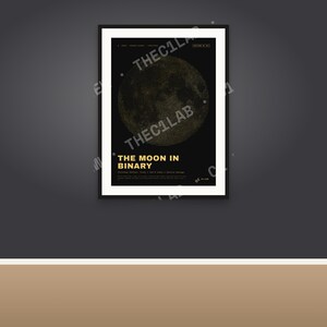 Peut inclure: Une affiche murale rectangulaire encadrée présentant un fond sombre avec un graphique lunaire circulaire composé de code binaire. Le texte indique THE MOON IN BINARY en lettres jaunes grasses, avec des détails textuels blancs en dessous.