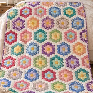Puede incluir: Una colcha con un patrón repetitivo de motivos florales hexagonales en varios colores, incluyendo rosa, azul, amarillo, verde y morado. Cada flor tiene un hexágono central amarillo rodeado por seis hexágonos más pequeños sobre un fondo blanco.