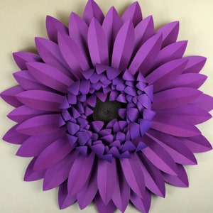 Pode incluir: Uma grande flor de papel artesanal em tons de roxo. A flor apresenta p&eacute;talas em camadas e um centro escuro, criando um efeito dimensional. Esta pe&ccedil;a decorativa &eacute; adequada para decora&ccedil;&atilde;o de parede ou estilo de eventos.
