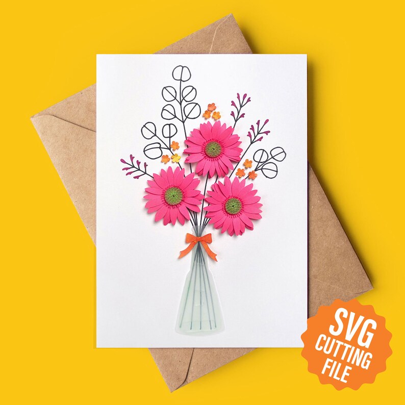 May include: A white card featuring a pink paper flower bouquet in a vase. The flowers have green centres and orange accents. The card has a black outline of the flowers and leaves. The text "SVG CUTTING FILE" is on an orange circle.