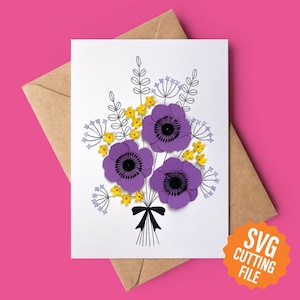 May include: A white card featuring a bouquet of purple and yellow paper flowers. The flowers are arranged in a vase and have a black ribbon tied around the stems. The card has the text "SVG Cutting File" in a yellow circle.