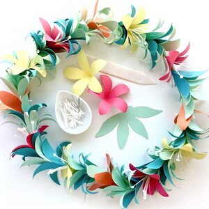 Pu&ograve; includere: Un lei di fiori di carta colorati con foglie verdi, fiori rosa, gialli e blu. Il lei &egrave; disposto in cerchio ed &egrave; perfetto per un luau o una festa tropicale.