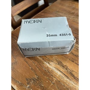 May include: A light gray rectangular cardboard box with the brand name MEIKAI printed in black on the top and front panels. The text 35mm 4351-0 is also printed in black on both the top and front surfaces of the box, which shows minor creasing.
