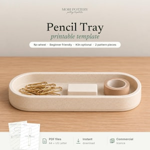 May include: A printable template for a pencil tray by Mori Pottery. The image shows an oval, speckled beige tray containing gold paper clips, a small rectangular block, and a roll of tape. Text includes "Pencil Tray printable template", "No wheel", "Beginner friendly", "Kiln optional", "2 pattern pieces", "PDF files", "Instant download", and "Commercial licence".