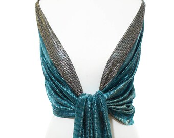 May include: Teal and gold metallic shawl with gold fringe. The shawl is draped over a white mannequin.
