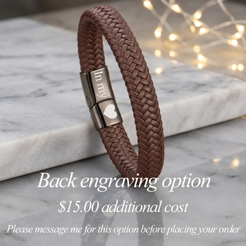 May include: A brown braided leather bracelet featuring a dark metallic magnetic clasp. The clasp is engraved with the text "In my" and a heart symbol. The bracelet has a textured, woven appearance and a secure, polished metal closure mechanism.