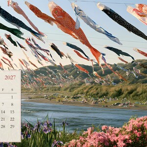 Peut inclure: Une page de calendrier de mai 2027 pr&eacute;sentant une photographie de paysage avec des banderoles de carpes color&eacute;es volant au-dessus d'une rivi&egrave;re et des azal&eacute;es roses au premier plan. Le texte indique MAY 2027, Children's Day - Carp Streamers et des kanjis.