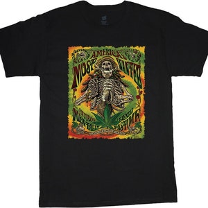 May include: Black t-shirt featuring a colourful graphic of a skeleton smoking a joint. The graphic includes the text "America's Most Wanted" and "Environmentally Friendly Pastime".