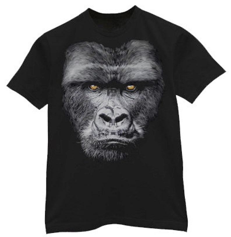 May include: Black t-shirt with a close-up image of a gorilla's face. The gorilla has a serious expression and piercing yellow eyes.