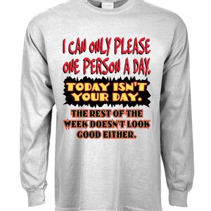 May include: A gray long-sleeve t-shirt with a humorous message printed in red and black. The text reads: "I can only please one person a day. Today isn't your day. The rest of the week doesn't look good either."