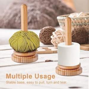 May include: Two bamboo yarn and paper towel holders with a vertical spindle and a circular base. One holder supports a ball of olive green yarn, while the other holds a roll of white paper towels. Text reads: Multiple Usage. Stable base, easy to pull, turn and tear.