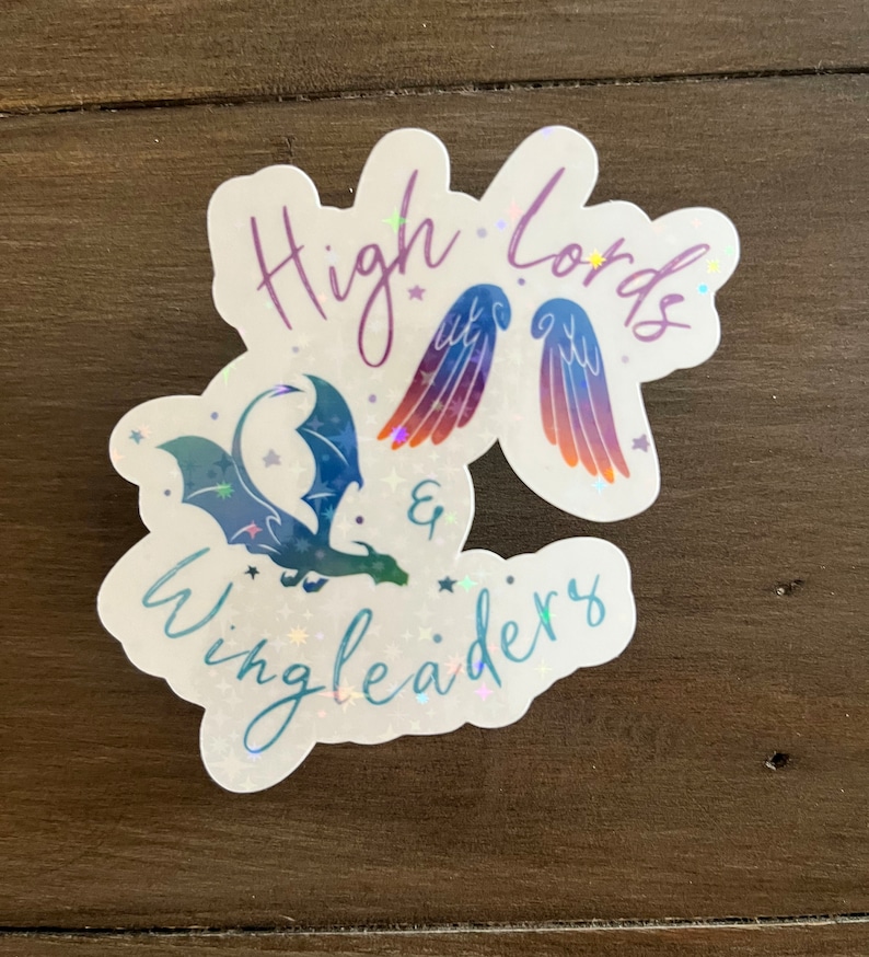 May include: A holographic sticker with a blue and green dragon and a pair of rainbow wings. The text "High Lords & Wingleaders" is written in a cursive font.