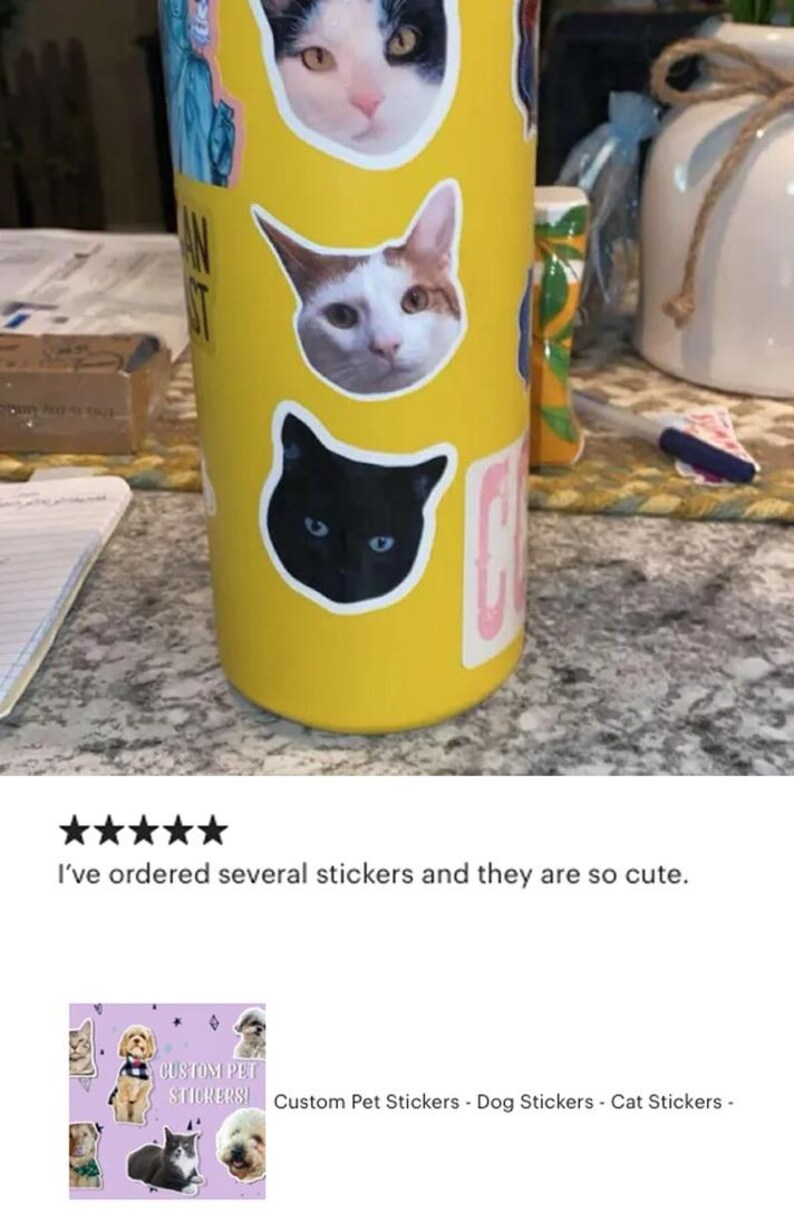 May include: Yellow tumbler adorned with cat face stickers. The tumbler has a sticker that says "AN ST". The image also shows a review with five stars and the text "I've ordered several stickers and they are so cute."