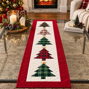 May include: A rectangular quilted table runner featuring a white center panel with five appliqued Christmas trees in various plaid patterns, each topped with a gold star. The runner has a wide red border with a diamond-stitched texture.